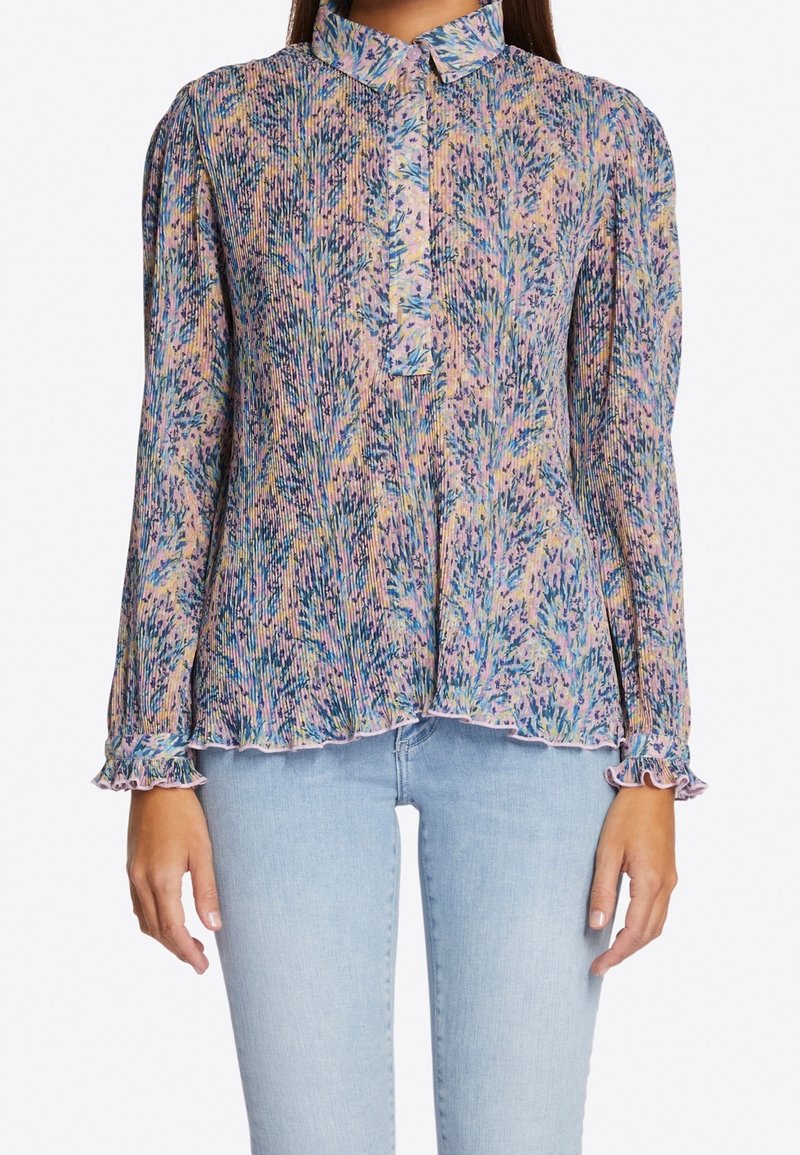Blusa plisada colorida con cuello tipo camisa, delicados puños con volantes y un patrón floral en tonos de azul, rosa y verde.