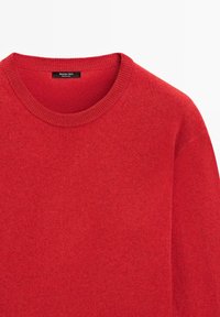 Pull rouge à col rond avec une texture fine en maille et une étiquette "Massimo Dutti" à l'intérieur du col, fabriqué en Chine.