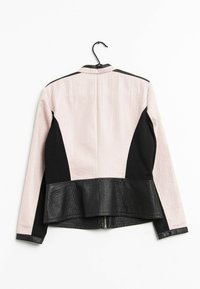 Veste noire et rose pastel avec un design peplum, tissu texturé et accents en cuir sur les manches et l'ourlet inférieur.