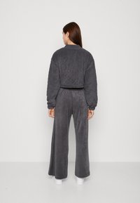 Grijze fleece loungewear set met een cropped lange mouwen top en wijde broek met een gladde textuur en een elastische tailleband.
