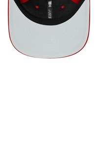 Schwarze und rote Kappe mit einem grauen Schirm. Flacher Rand, kontrastierende rote Nähte und ein strukturiertes Gewebe. Das Innenfutter zeigt ein Markenlabel.