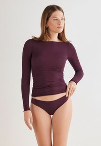 Bordeaux langemouwen top met een getailleerd ontwerp en geplooide details bij de taille, gecombineerd met bijpassende low-rise bikini broekjes. Glad, gestructureerd materiaal.