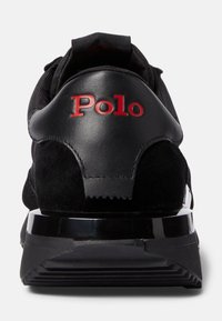 Svart sportskor med en kombination av slätt läder och mocka, med röd "Polo"-logotyp på hälen och en elegant, texturerad sula.