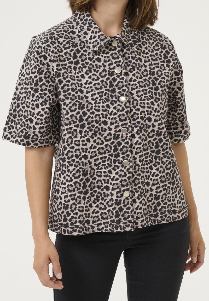 Leopard print short-sleeve shirt in beige and black, featuring a button-up front and a classic collar. Soft fabric with a smooth texture.
