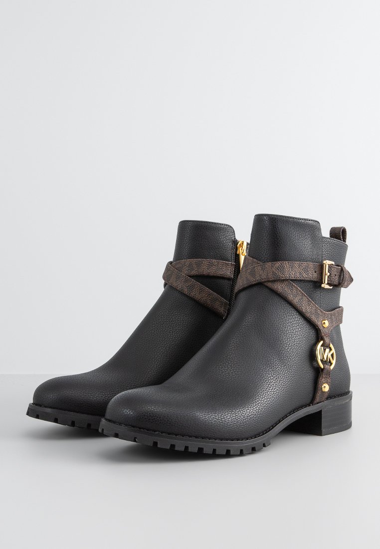 Stivaletti neri alla caviglia con finitura in pelle testurizzata, dotati di cinturini incrociati marroni, hardware dorato di accento e un tacco a blocco basso.