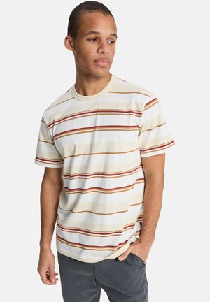 Maglietta a maniche corte a righe con bande orizzontali in rosso, arancione e crema su uno sfondo beige chiaro, realizzata in morbido tessuto di cotone.