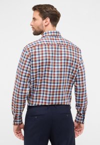 Geruit katoenen shirt met rode, blauwe en witte vierkanten. Achteraanzicht toont een klassieke kraag en knoopmanchetten. Tailored fit ontwerp.