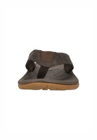 Brun sandal med en texturerad gummisula, justerbar rem och perforerade accenter. Har en strömlinjeformad design för komfort och stöd.