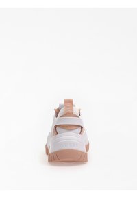 Sneaker bianca con accenti color cuoio, suola testurizzata e linguetta con marchio. Design del tallone aperto con una combinazione di materiali lisci e traforati.