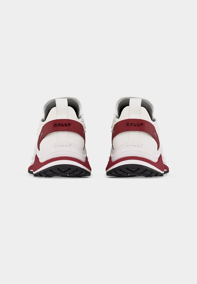 Paire de baskets blanches et bordeaux avec semelles noires, vues de dos, montrant une languette et le nom de la marque sur la sangle du talon.