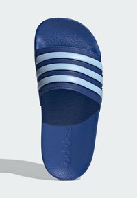 Sandal azul de encaixe com material texturizado, três riscas azul claro na parte superior e logotipo em relevo na palmilha.