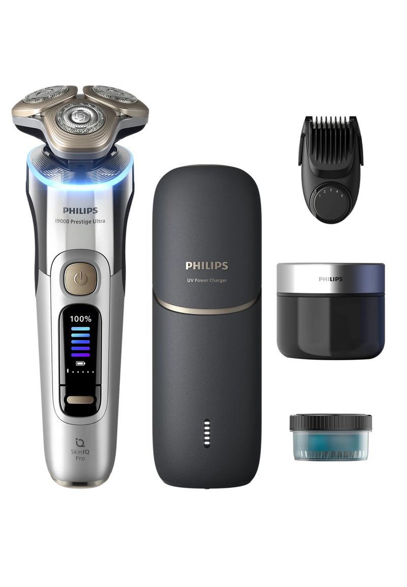 Philips i9000 Prestige Ultra elektrische scheerapparaat met chromen en zwarte behuizing, drie metalen scheerkoppen, UV-voedingstekker, verzorgingsaccessoire en huidverzorgingsproducten.