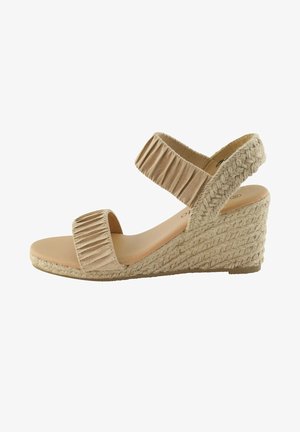 Sandalia de cuña beige con tacón de yute trenzado, que cuenta con dos tiras de tela plisada y una plantilla lisa. Vista lateral que muestra un diseño curvado.