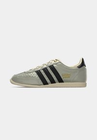 Szare zamszowe sneakersy z trzema czarnymi paskami, perforowanym wzorem, beżową gumową podeszwą i złotym oznaczeniem "adidas JAPAN" na boku.