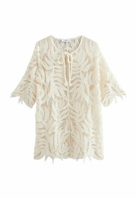 Lace tunika i off-white med blomstermønster, halværmer, bindebånd foran og bølget kant. Letvægtigt, tekstureret stof.
