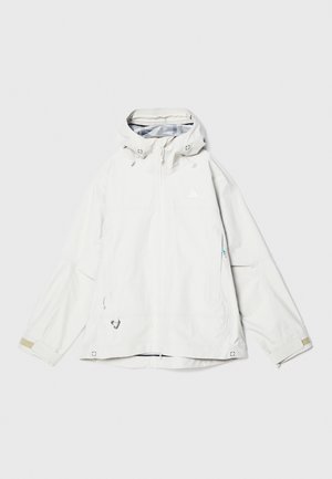 White waterproof jacket with a zippered front, adjustable hood, and multiple pockets. Features a smooth texture and minimal branding.