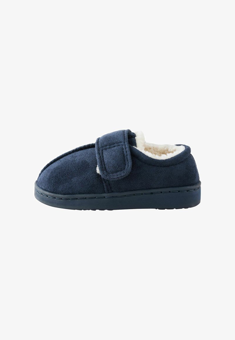 Chausson bleu marine avec extérieur en tissu doux, bride réglable à fermeture auto-agrippante et doublure intérieure blanche et moelleuse.