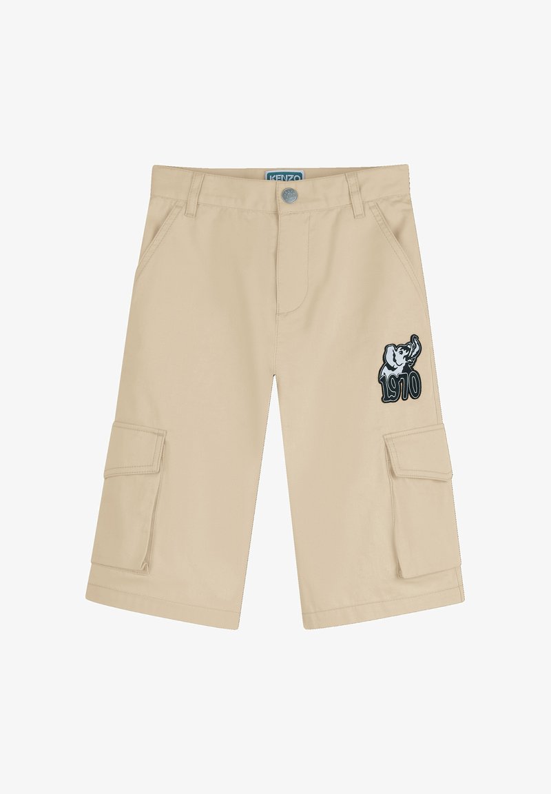 Shorts cargo beiges avec poches avant, poches à rabat latérales, fermeture par boutons et un écusson éléphant avec "1970" sur la jambe droite.