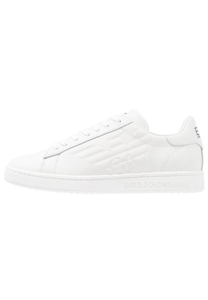 Baskets basses blanches avec logo aigle embossé sur le côté, fermeture à lacets, et marquage "EA7 Emporio Armani" sur la semelle et la languette du talon.
