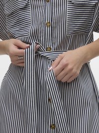 Robe rayée en blanc et bleu marine avec un devant boutonné, deux poches avant et un détail de taille nouée. Tissu doux avec une finition légèrement texturée.