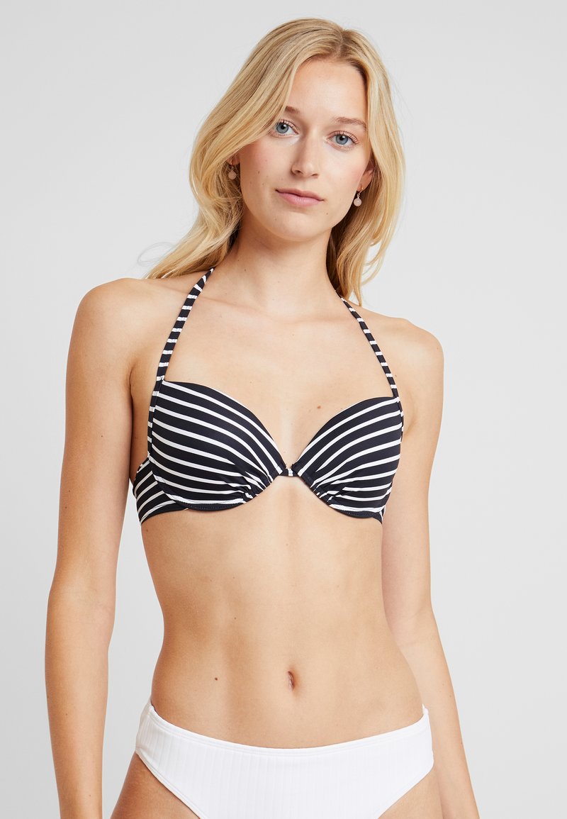 Bikini top s čierno-bielymi pruhmi a prekrúteným predným dizajnom; s popruhmi okolo krku; hladká textúra; v kombinácii s jednoduchými bielymi bikini spodkami.