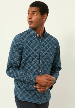 Langärmliges Hemd aus dunkelblauem Stoff mit einem geometrischen Muster, Button-down-Kragen und Knopfverschlüssen, mit einer taillierten Silhouette.