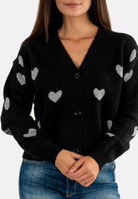 Cardigan nero con motivi a cuore argentati, collo a V e chiusura con bottoni. Texture lavorata a maglia e maniche lunghe. Design casual.