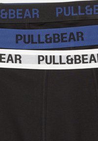 Livremmes af tre par sorte underbukser med "PULL&BEAR"-mærket tekst i sorte, blå og hvide elastikbånd.