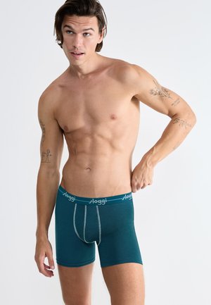 Boxer da uomo color teal con vestibilità aderente. Tessuto morbido, cintura elastica con logo "Sloggi" bianco e dettagli di cucitura a contrasto.