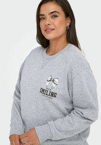 Felpa grigia in misto cotone, con colletto rotondo, maniche lunghe e una stampa di un fiocco con la scritta "CONTINUA A SORRIDERE."
