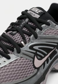 Nike Air Max 2K-sneakers i grått med svarta accenter. Har ovandel i mesh, gummisula, vadderad krage och kontrasterande logotyp.