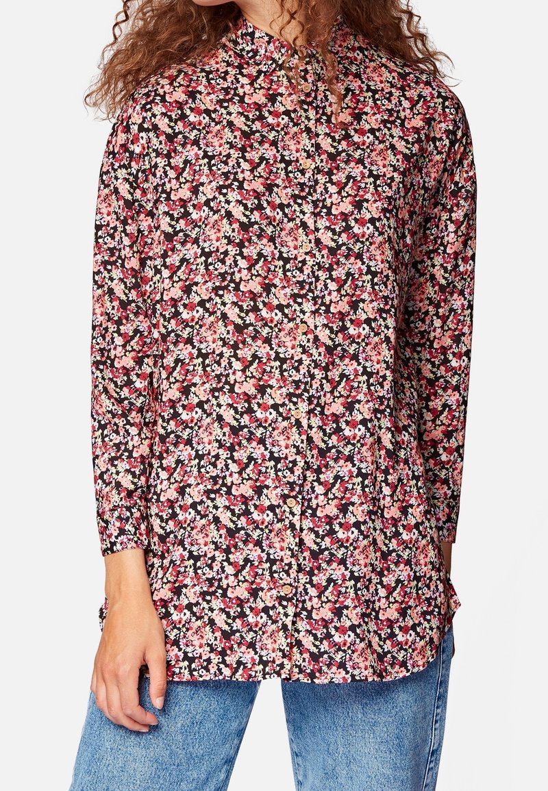Camicia floreale con bottoni nera con fiori rosa e crema, maniche lunghe e scollatura alta. Tessuto morbido con vestibilità ampia.