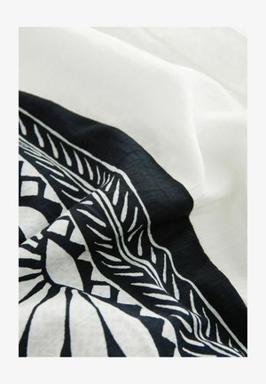 Bufanda de patrón en blanco y negro con una textura suave y ligera. Presenta un diseño geométrico a lo largo de los bordes.