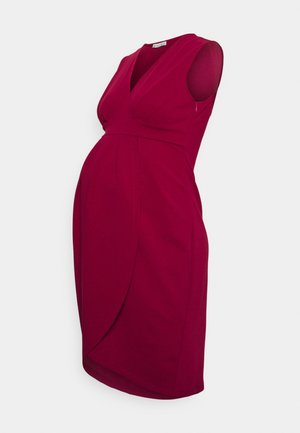 Robe de maternité rouge sans manches avec décolleté en V, devant croisé et taille empire cintrée conçue pour accueillir un ventre arrondi.