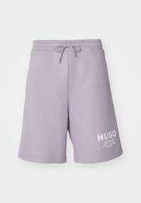 Shorts lilas clair à cordon avec taille élastique et logo Hugo blanc sur la partie inférieure de la jambe gauche.