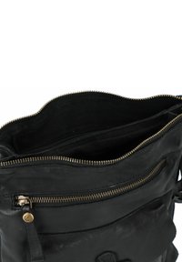 Borsa in pelle nera di forma rotonda, con una zip dorata, due scomparti interni e una tasca frontale con chiusura a zip.