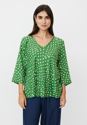 Zielony top z dekoltem w kształcie litery V, rękawami do łokcia i luźnym krojem. Całość ozdobiona białym wzorem w groszki. Miękka faktura materiału.