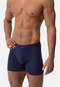 Navy blue boxer shorts made from soft fabric, featuring a contrasting red waistband with logo, snug fit, and a smooth texture.