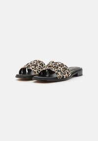 Leopardo raštas skaidrės sandalai su dirbtinės odos viršumi, atviru pirštu ir žemu bloko kulnu, kurio aukštis yra maždaug 2,5 cm.