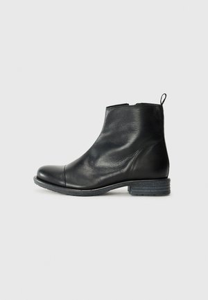 Schwarze Leder-Ankle-Boots mit runder Spitze, niedrigem Blockabsatz, glatter Textur und einer Zuglasche auf der Rückseite für einfaches An- und Ausziehen.