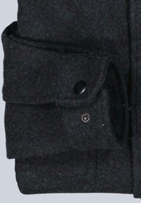 Dunkelgrauer Wollmantelärmel mit einer Klapptasche, die mit einem schwarzen Druckknopf gesichert ist, und sichtbaren Nähdetails.