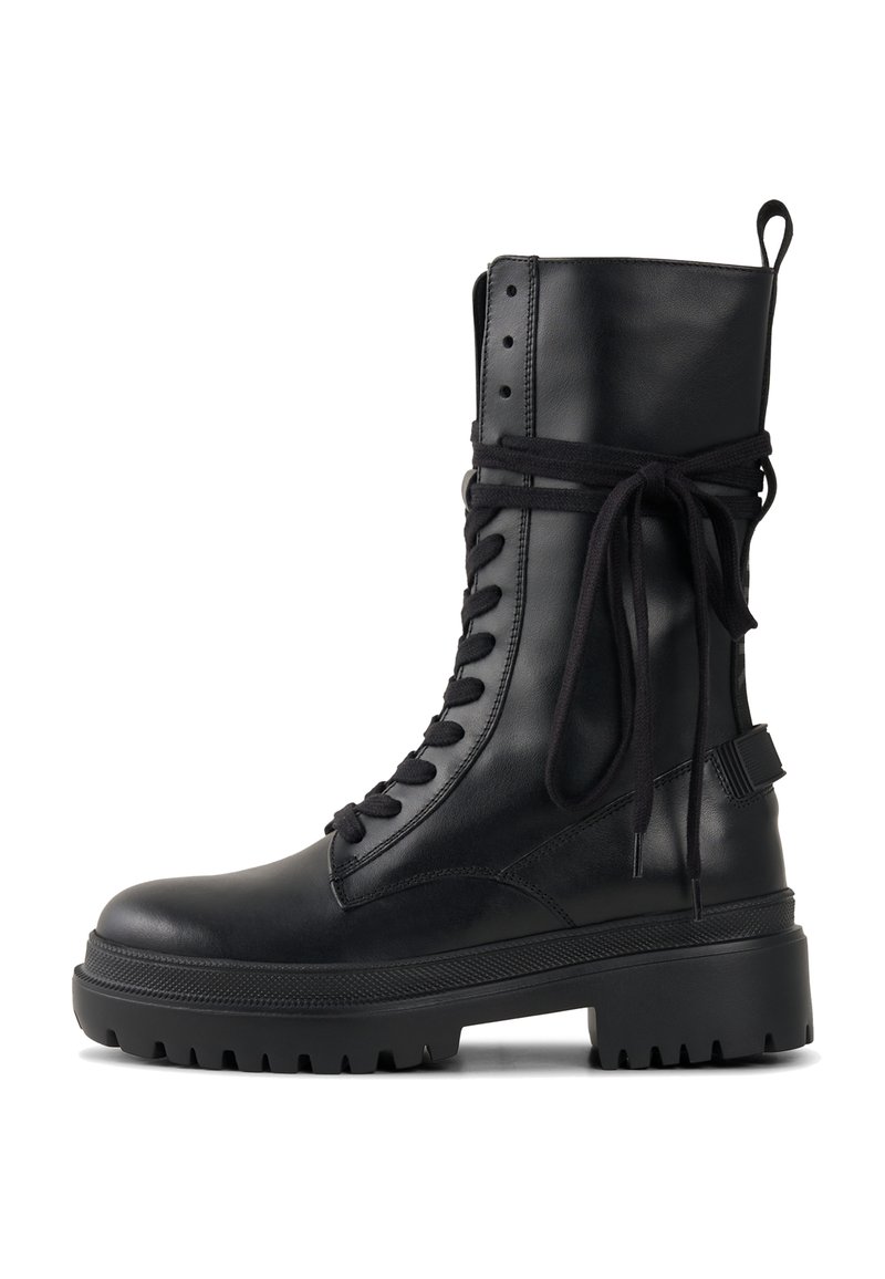 Czarny skórzany botek za kostkę na sznurowadła z masywną podeszwą, teksturowanymi akcentami i tkaninowym detalem owiniętym wokół góry. Wyposażony w pętlę do ściągania.