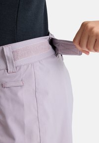Light purple pants with a fabric waist adjustable by Velcro. Textured material with a smooth finish and contrasting stitching details.