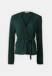 Blusa avvolgente verde scuro a maniche lunghe con delicate pieghe verticali e una cintura annodata in vita, su uno sfondo chiaro e semplice.