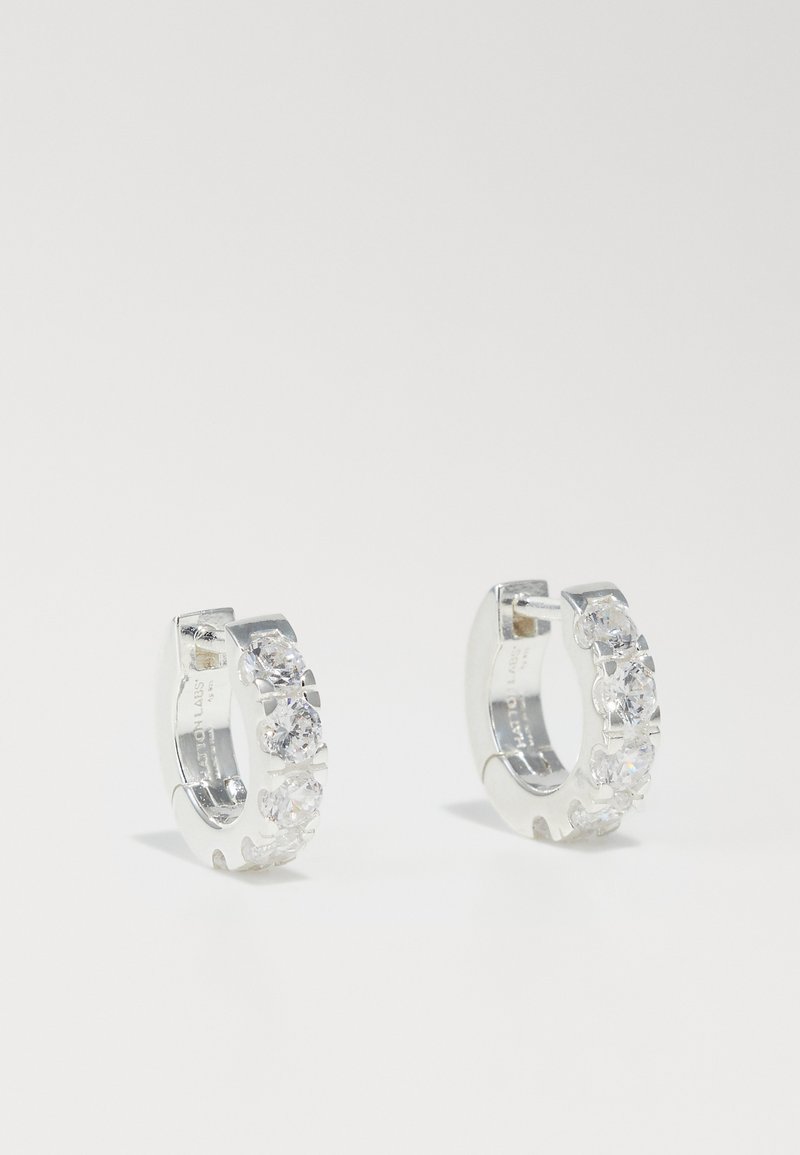 Silver hoop earrings with a row of clear, round crystals along one side. Rounded shape, smooth metallic surface, and secure clasp design.