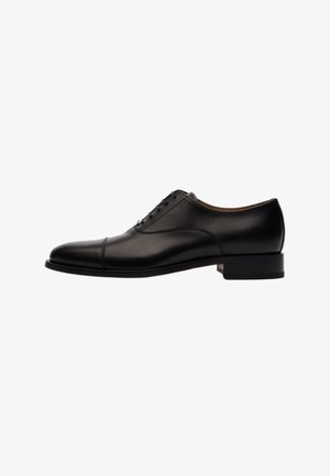 Zwarte leren veterschoen met een ronde neus, cap toe-detail en een lage blokhak. Soepele textuur met subtiele stikselaccenten.