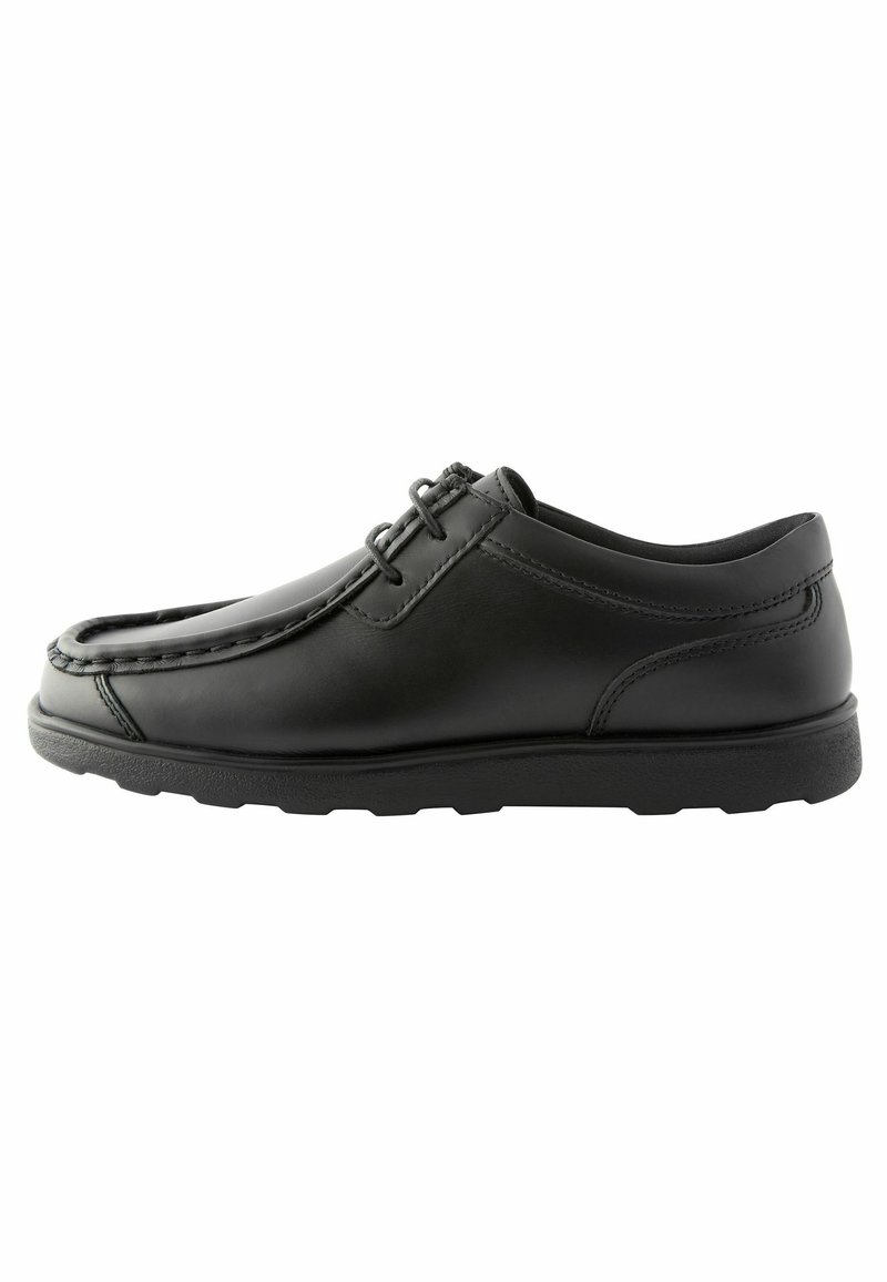Chaussures en cuir noir avec une finition lisse, bout rond, couture minimale et semelle en caoutchouc plate. Présente un système de laçage et un design structuré.