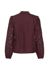 Blouse bordeaux avec de longues manches en dentelle, dos plissé, col montant et tissu texturé. La dentelle présente des motifs floraux.