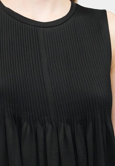 Μαύρο αμάνικο φόρεμα με κάθετες πιέτες στο μπούστο και συγκεντρωμένο ύφασμα κάτω από τη μέση.