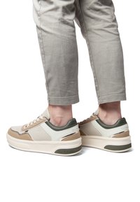 Låga sneakers med beige, grön och krämfärgad syntetisk material. Rundad tå, snörning framtill, vadderad krage, tjock sula med logotyp.